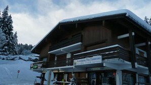 Un bâtiment à deux étages, sur lequel on peut voir une enseigne indiquant qu’il s’agit d’un restaurant. De la neige recouvre le toit et le sol.
