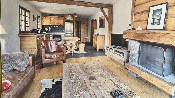 Un intérieur rustique avec une table à manger en bois, un canapé en cuir et une cheminée.