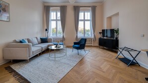 A modern living room with a sofa, armchair, coffee table, and a TV stand.