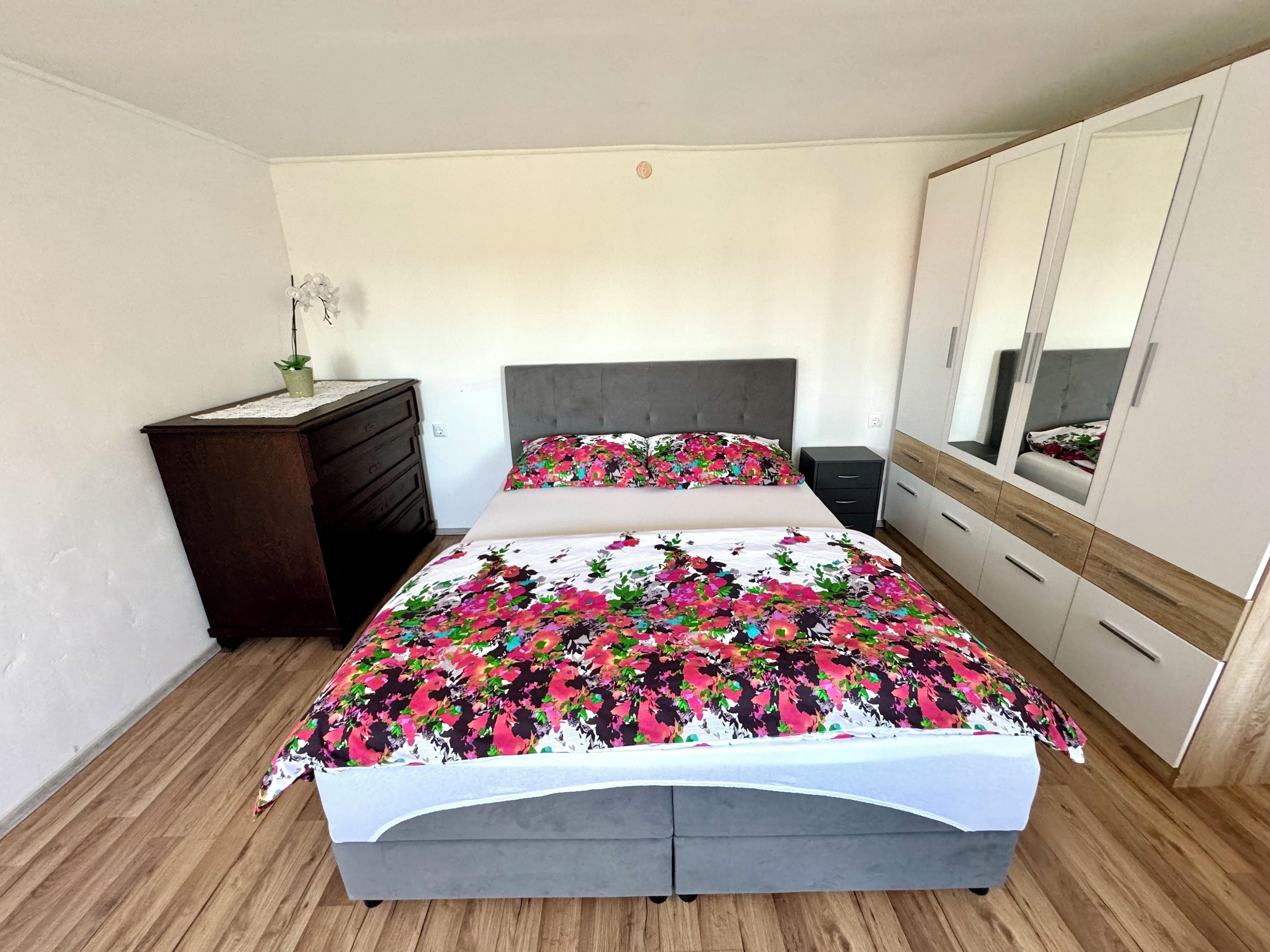 Ein Schlafzimmer mit einem Bett, einem Schminktisch, einem Nachttisch und einem Kleiderschrank.