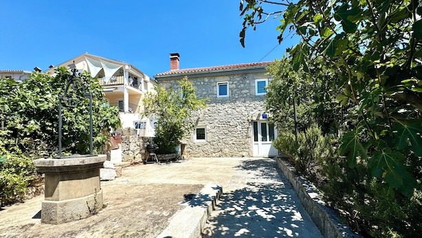 A courtyard with stone buildings, a grill, and a pergola. - Holiday house Adria (Crikvenica)