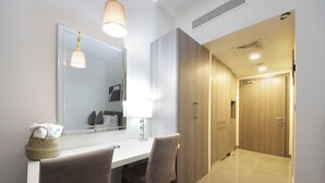 A modern bathroom with a large mirror, a vanity with a light, and a shower area. - Bloomfields STU with Balcony Leonardo (Abu Dhabi)
