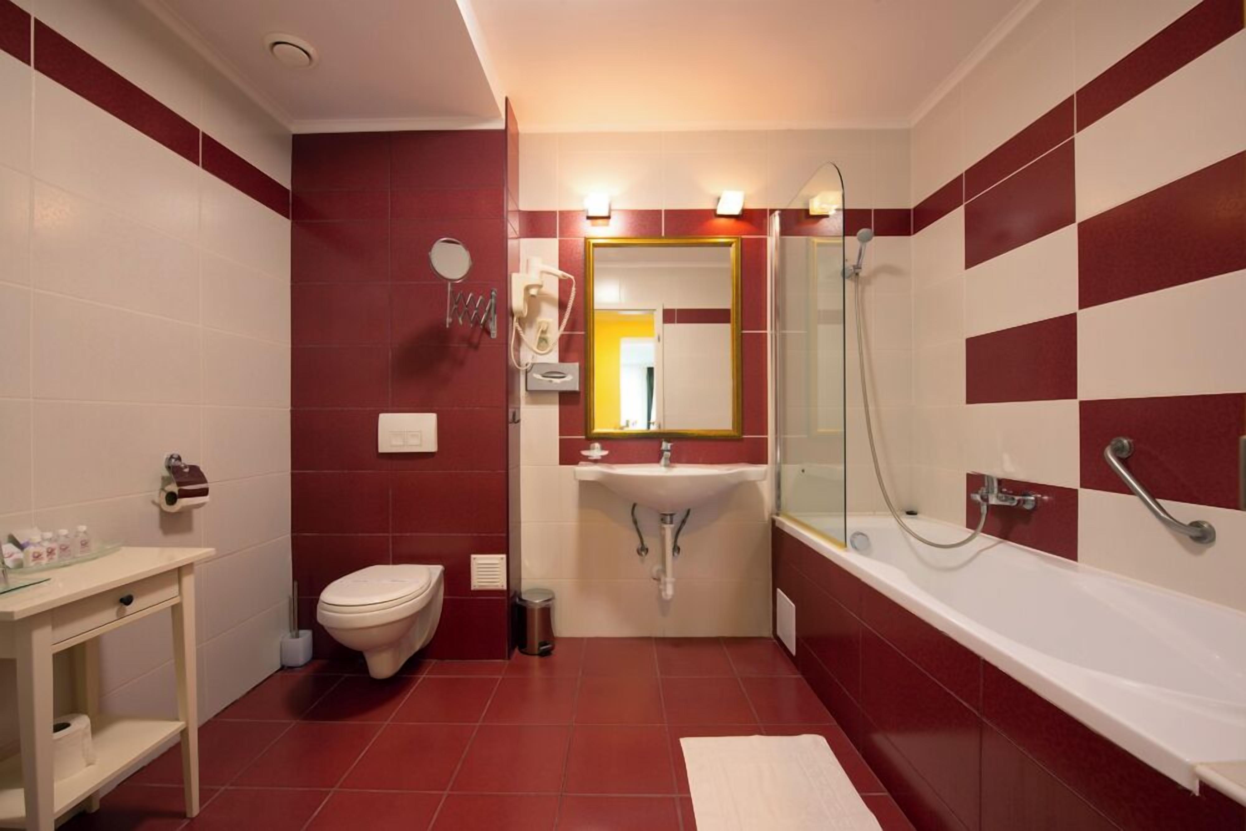 Une salle de bain avec des toilettes, un lavabo et une baignoire.