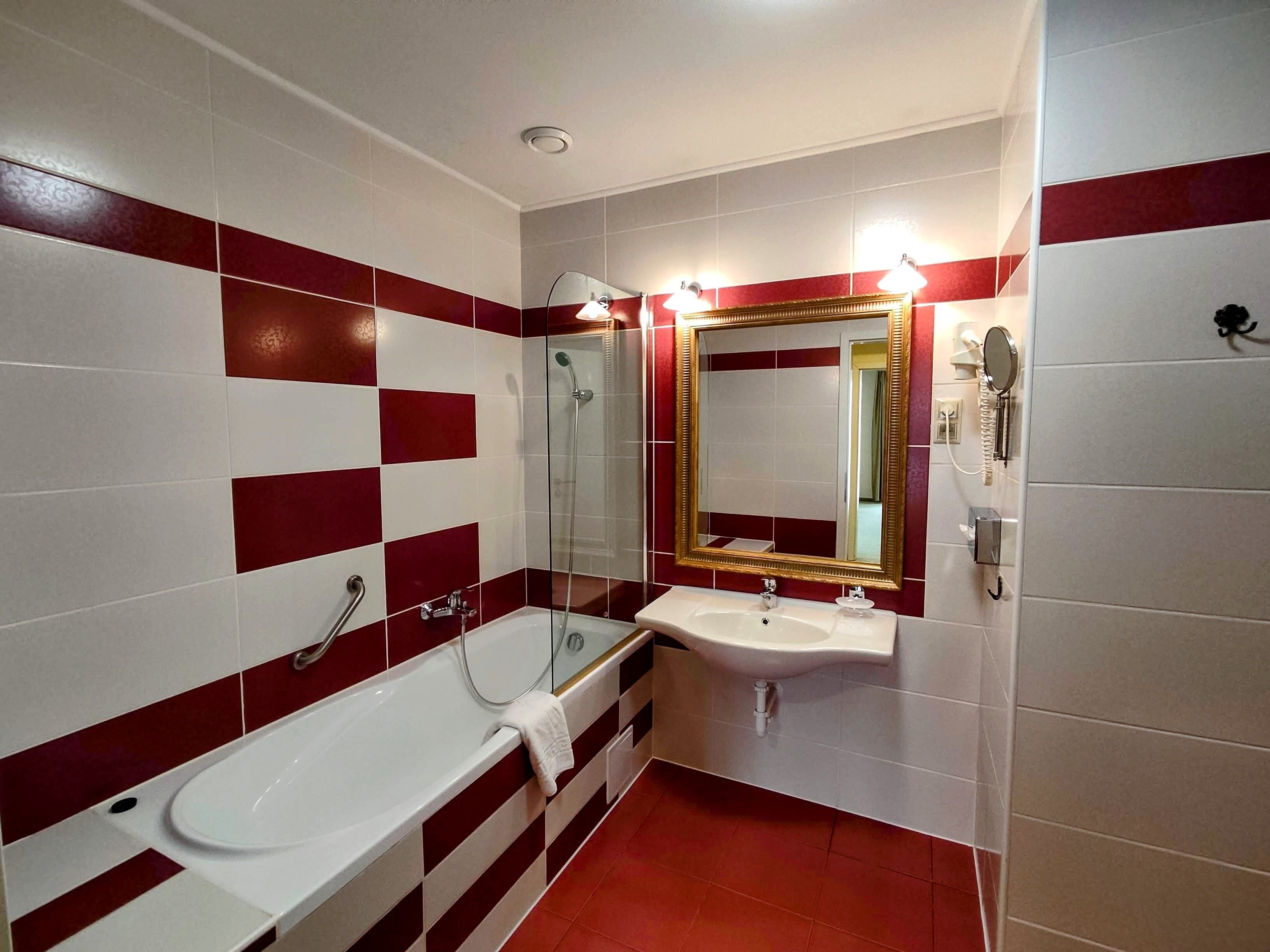 A bathroom with a bathtub, a shower, and a sink.