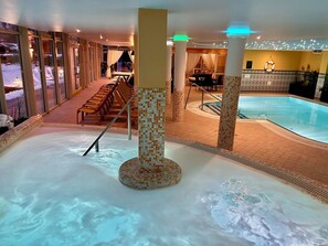 A spa area with a hot tub, seating area, and a pool. - Calimbra Wellness and Conference Hotel (Miskolc)