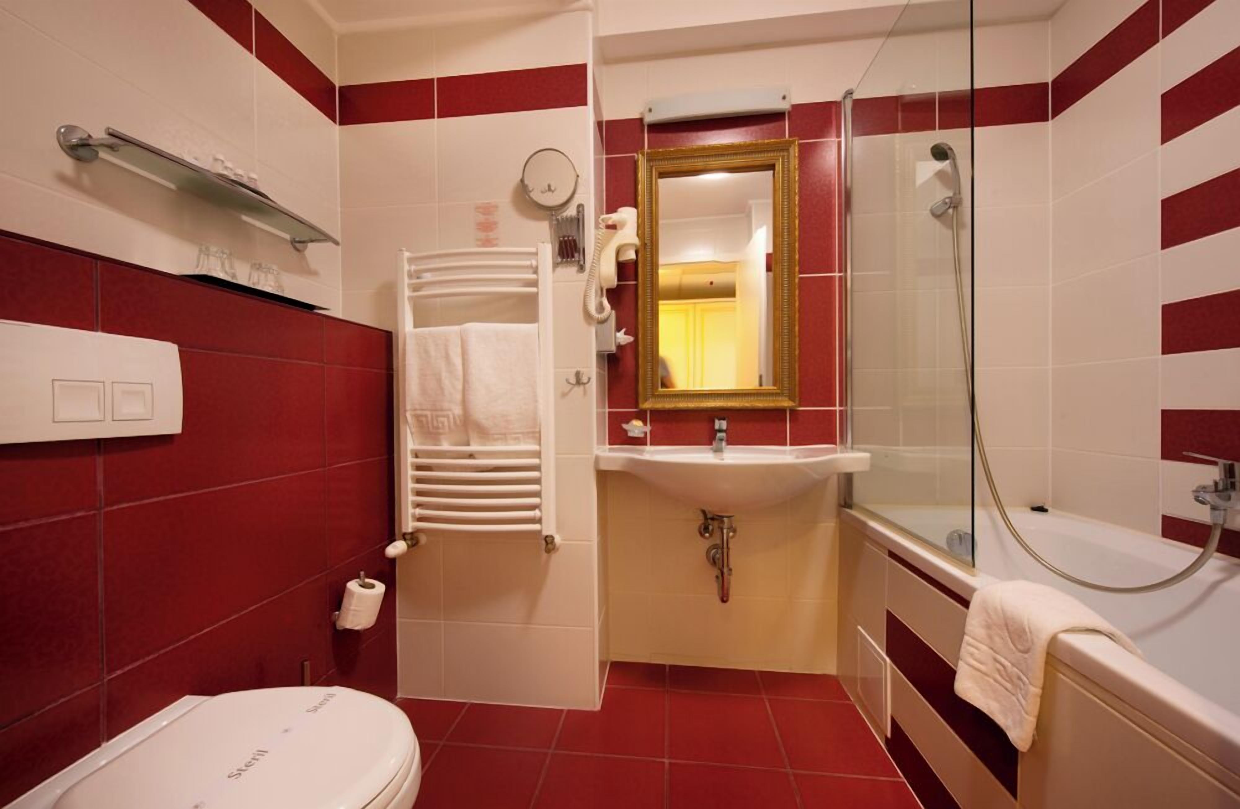 Un baño con inodoro, lavamanos y ducha.