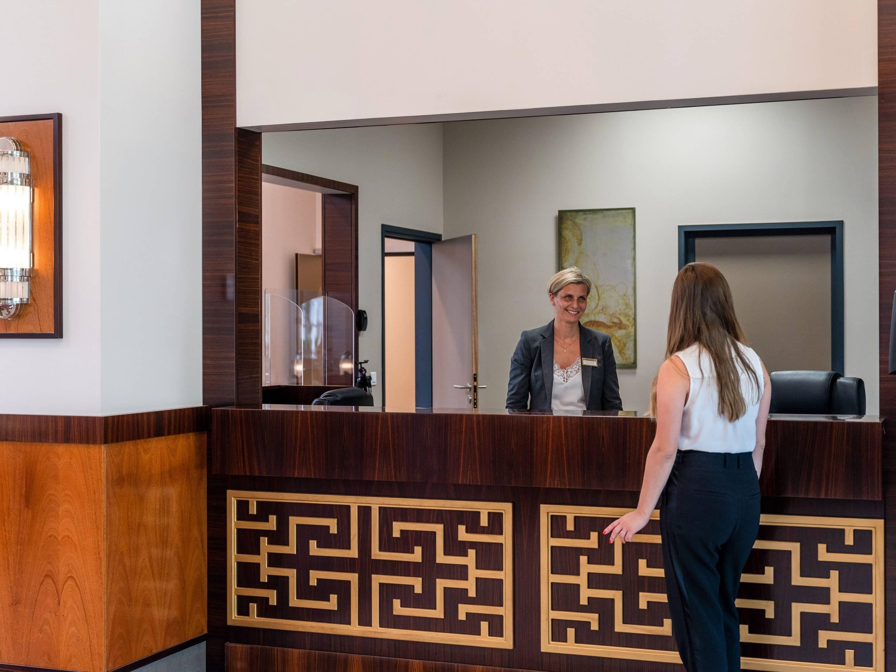En receptionsdisk med en trädesign och en namnskylt.