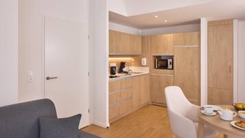 A modern kitchen with wooden cabinets, a microwave, and a dining area with a table set for breakfast.