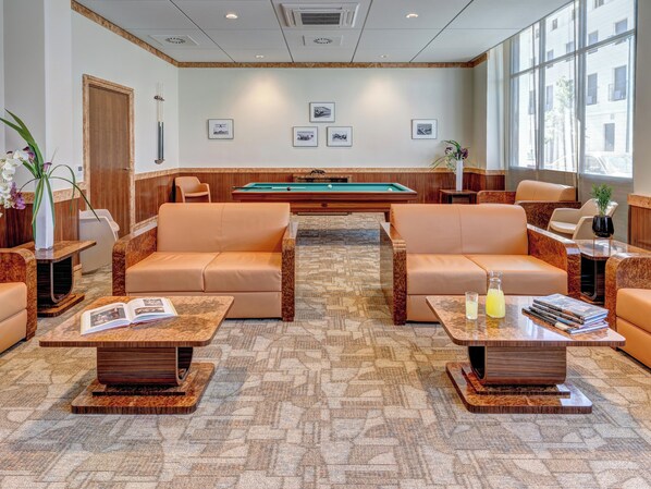 A modern lounge area with leather sofas, a pool table, and a large window providing a view of the city. - Zenitude Hôtel-Résidences Val d'Europe (Chessy)