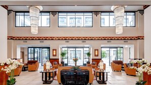 A spacious lobby with a central seating area, large windows, and decorative lighting fixtures. - Zenitude Hôtel-Résidences Val d'Europe (Chessy)