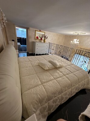 Relax in a spacious bedroom with a plush bed, dresser, and balcony offering a view of the outside.