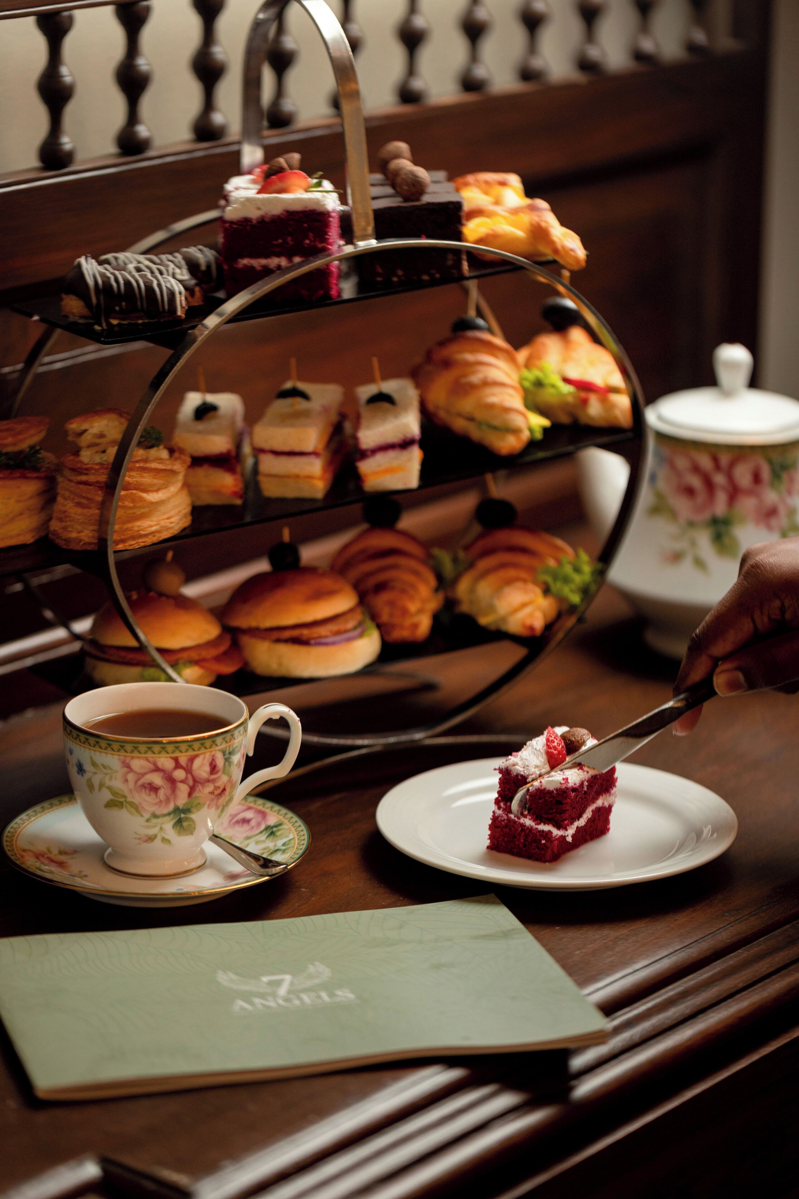 Une présentation de desserts à étages, avec divers pâtisseries, et une tasse de thé sur une table.