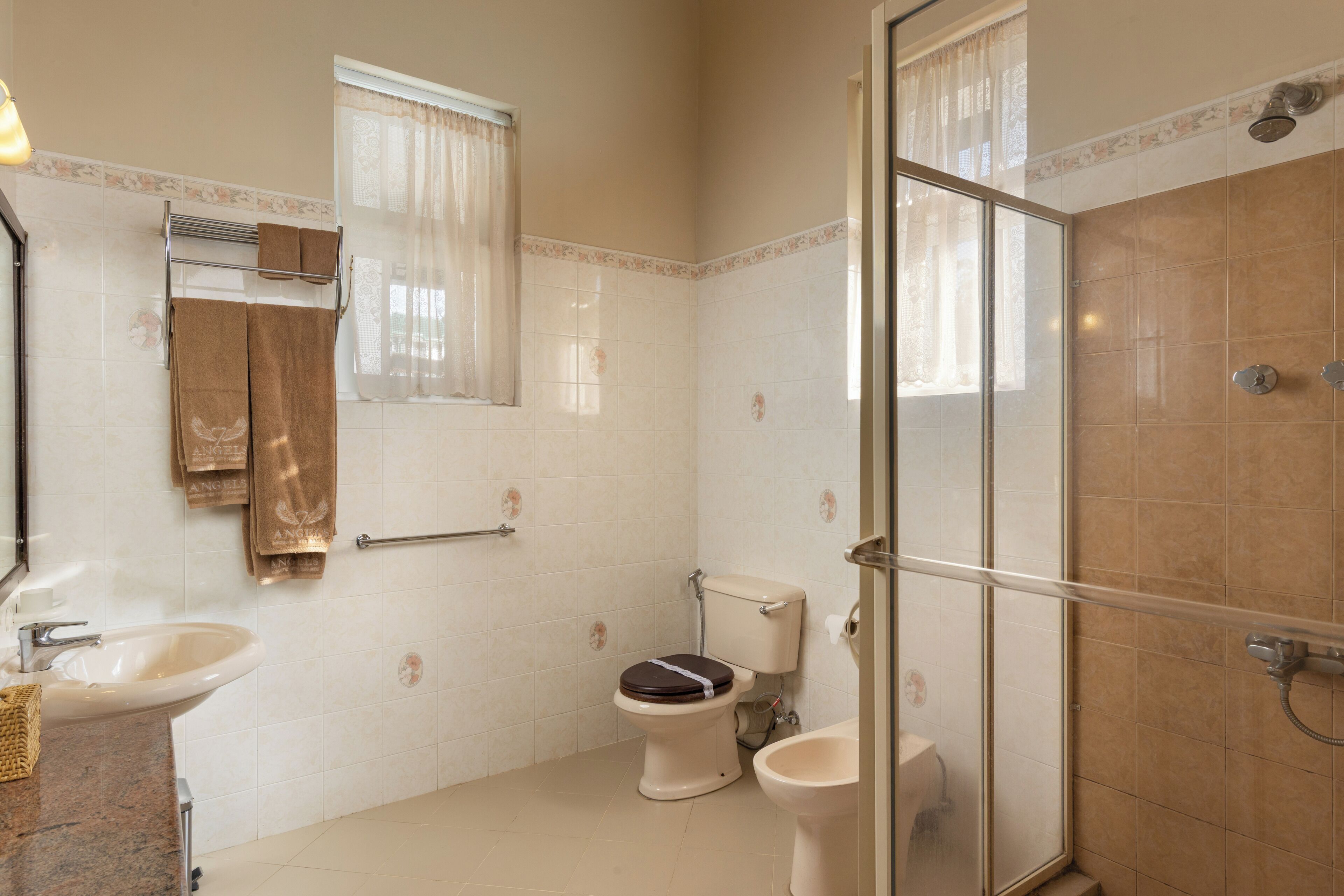 Un bagno con WC, bidet e zona doccia con pareti in vetro.