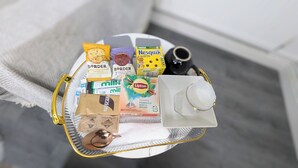 Tarjoilualusta, jossa on pientä purtavaa, teepusseja ja lusikka.
