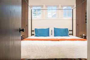 Een slaapkamer met een bed, een raam en een deur.