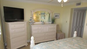 A bedroom with a bed, dresser, television, and a ceiling fan. - Panoramic Oceanfront Condo | Balcony +Beach Access (Saint Augustine)