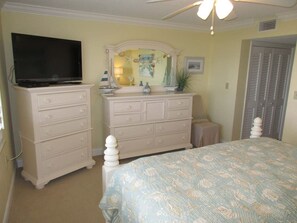A bedroom with a bed, dresser, television, and a ceiling fan. - Panoramic Oceanfront Condo | Balcony +Beach Access (Saint Augustine)