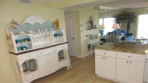 A kitchen with a white cabinet, a countertop, and a door leading to another room. - Panoramic Oceanfront Condo | Balcony +Beach Access (Saint Augustine)