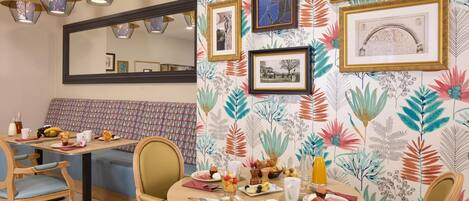 Un comedor con una mesa redonda dispuesta para el desayuno, con platos de comida, bebidas y una variedad de cubertería.