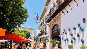 A bustling street with outdoor seating, potted plants, and a bicycle. - Marbella Old Town - pedestrian area - walk to beach (Marbella)
