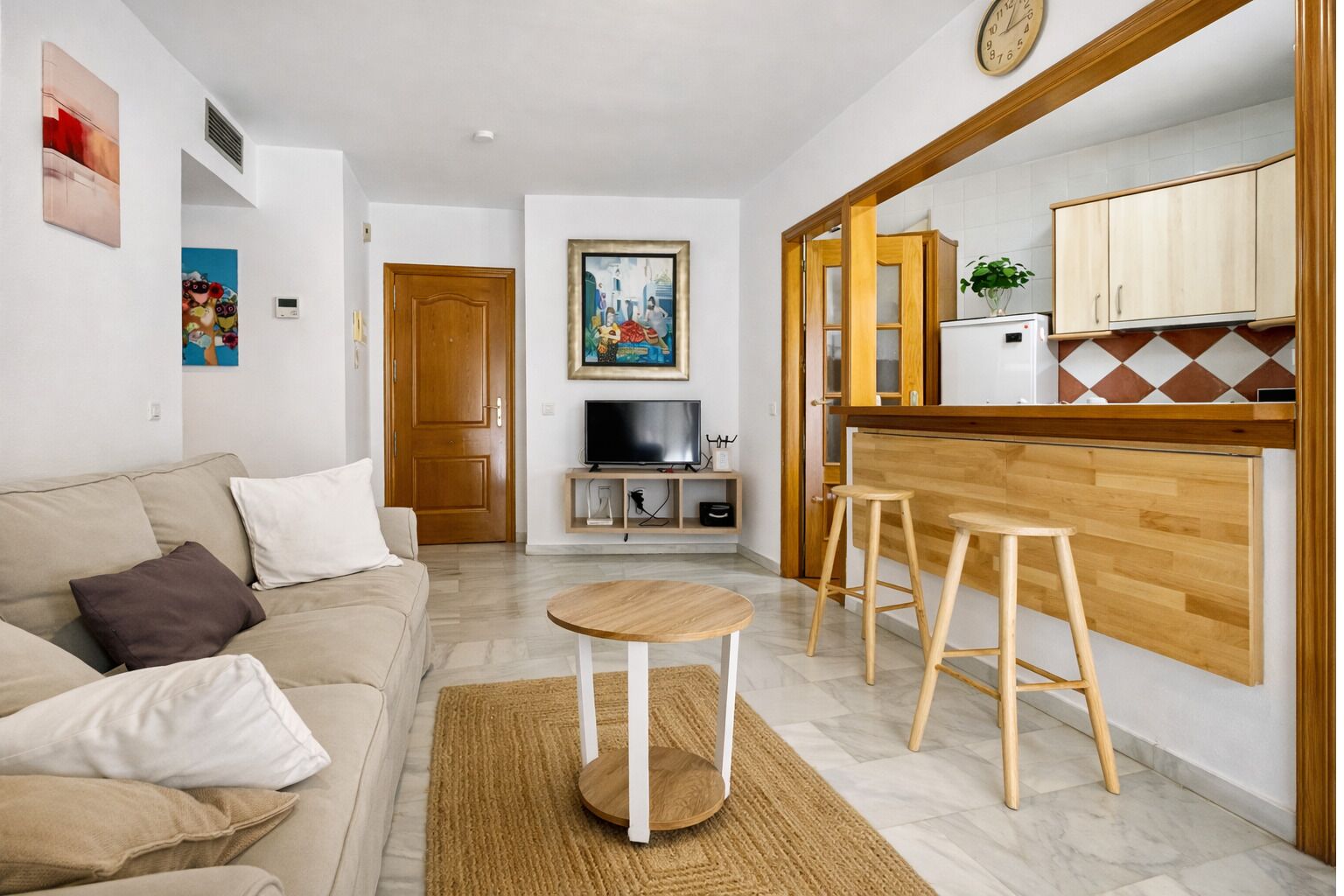 Ein Wohnzimmer mit einer Couch, einem Couchtisch und einer TV-Kommode.