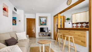 A living room with a sofa, a coffee table, and a TV stand. - Marbella Old Town - pedestrian area - walk to beach (Marbella)