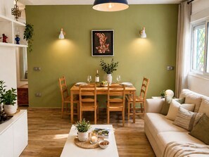 Ein Essbereich mit einem Holztisch, Stühlen und einem Bild an der Wand.