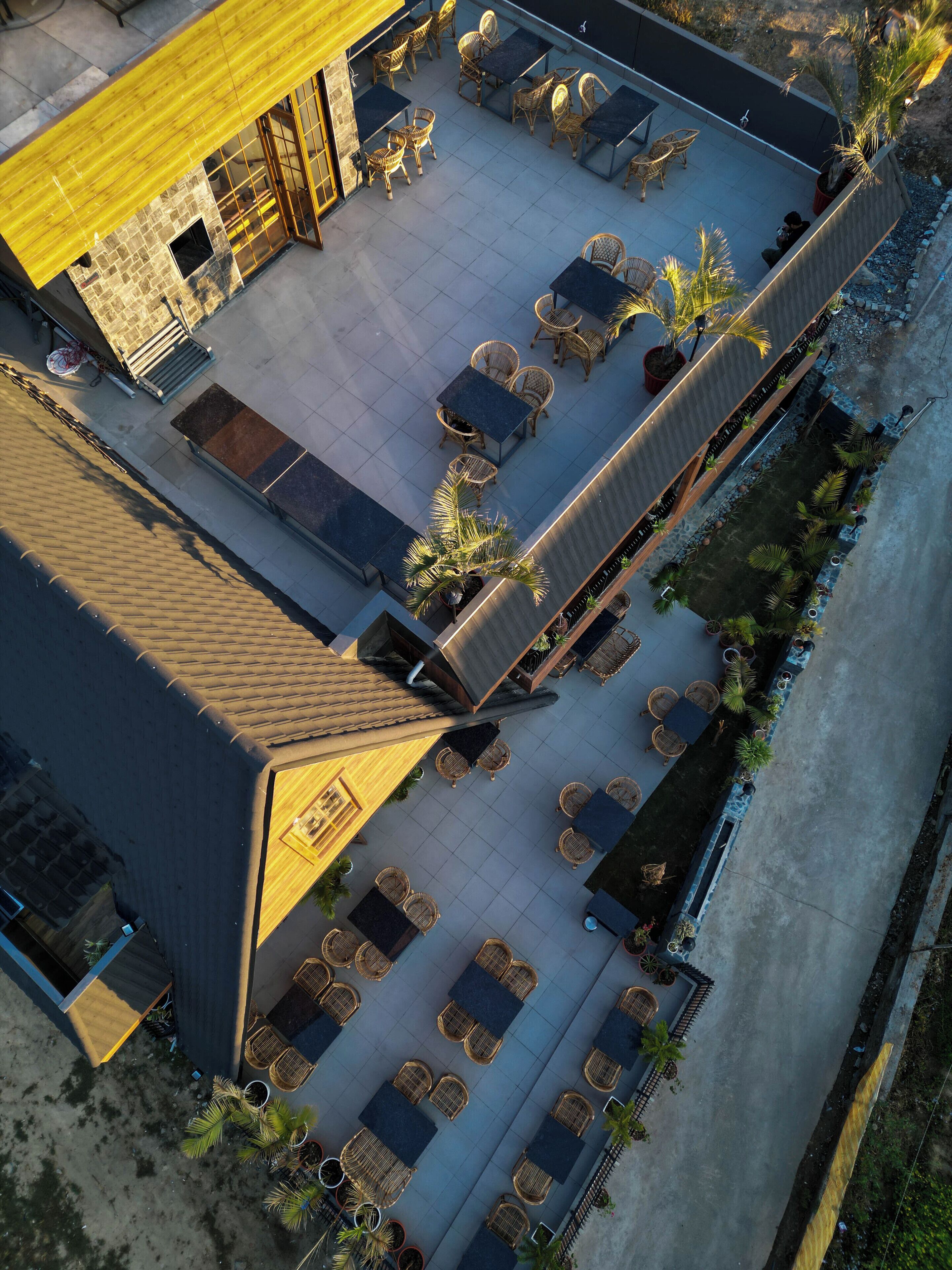 Vista aérea de una terraza en la azotea con mobiliario exterior y una pequeña área ajardinada.