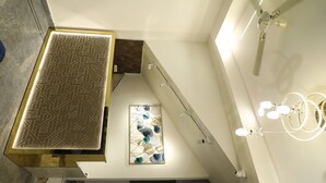 A modern interior with a geometric patterned table, a decorative wall piece, and a ceiling fan. - THE NECTAR HOTEL  (Hyderabad)