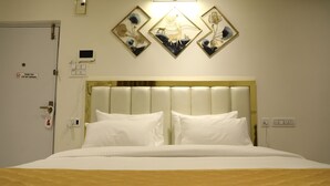 A hotel room with a bed, a door with a 'Thank You' sign, a thermostat, and wall-mounted artwork. - THE NECTAR HOTEL  (Hyderabad)