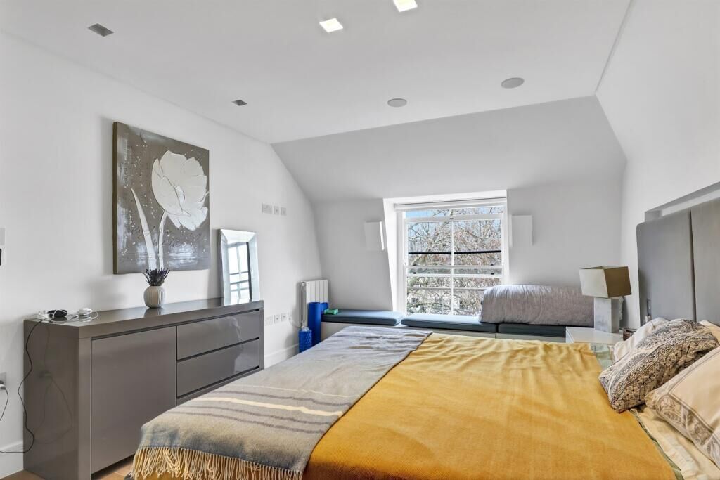 Un dormitorio con cama, cómoda, ventana y un cuadro en la pared.