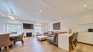 A spacious living area with a dining table, sofas, and a fireplace. - Luxury 2 Bedroom Hyde Park Penthouse with Rooftop (London)