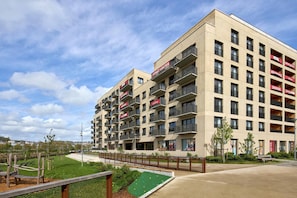 A multi-story hotel with balconies, a playground, and a green area.