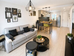 Un salon moderne avec un canapé, une table basse et des œuvres d’art accrochées au mur.