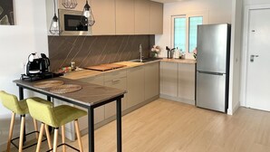 A modern kitchen with a central island, stainless steel appliances, and pendant lighting. - Esperanza Grand Apartments II • Marbella Centro (Marbella)