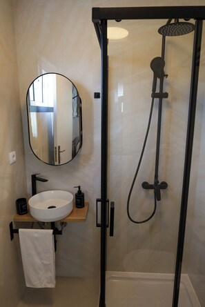 Chuveiro, toalhas de banho, sabonete, papel higiênico