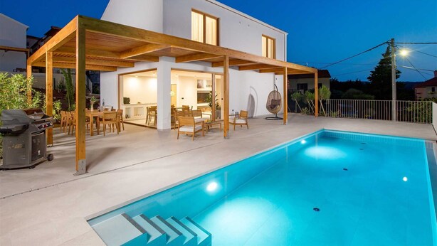 A modern house with a swimming pool, wooden pergola, and a dining area. - Villa 1 (Soline)