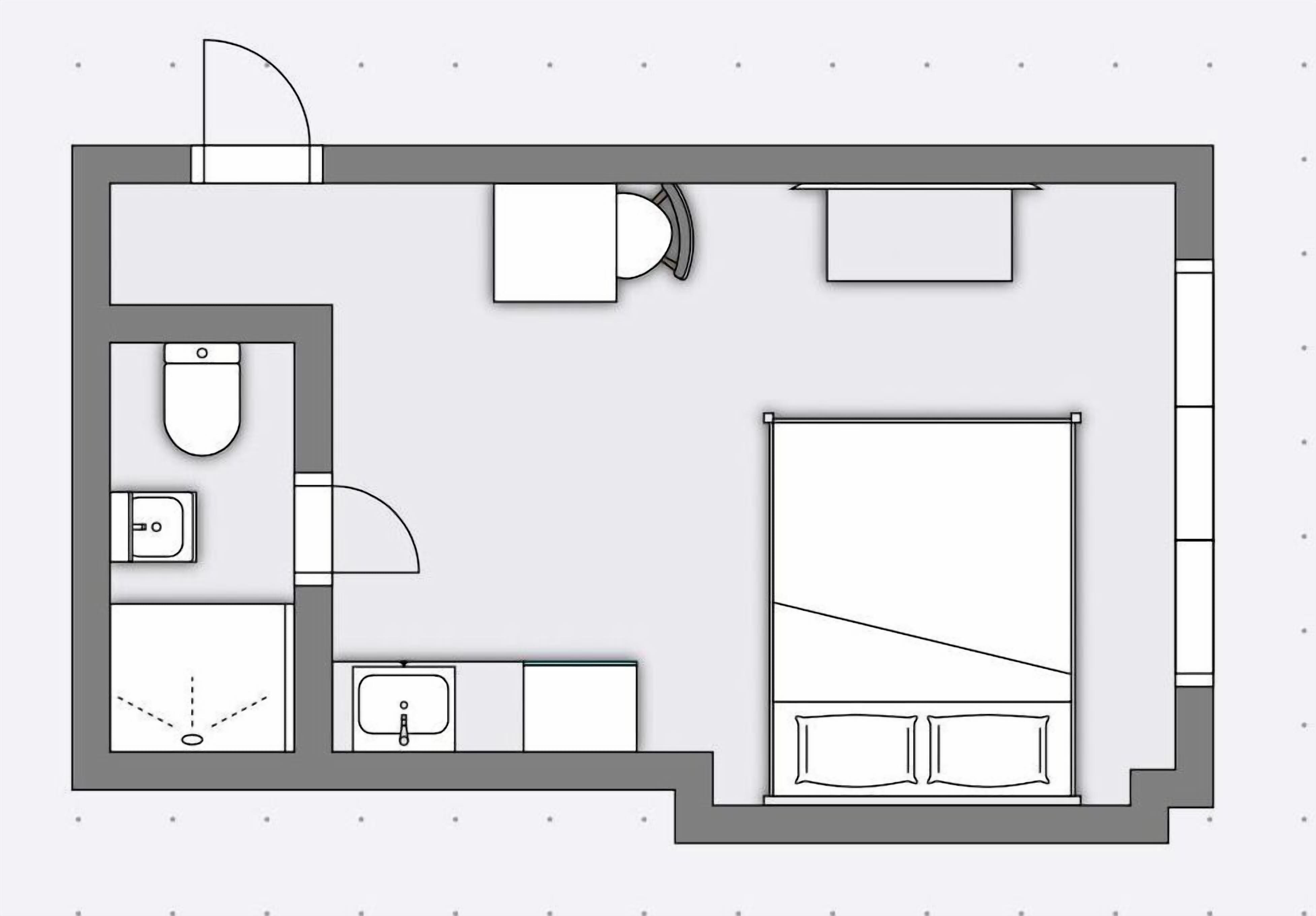 A floor plan of a hotel room with a bed, a bathroom, a small seating area, and a kitchenette.