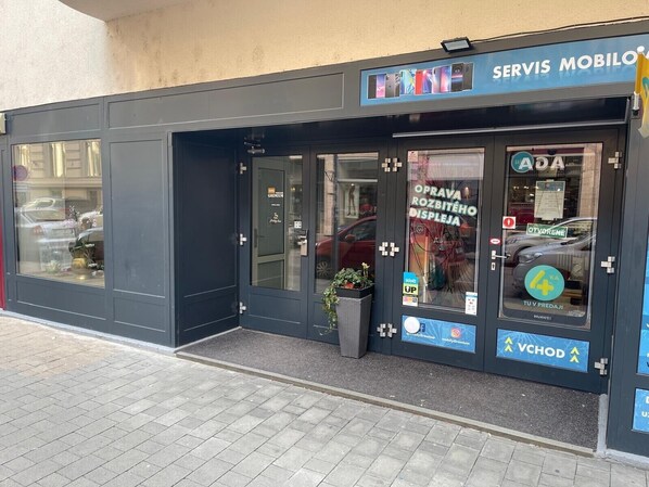 A storefront with a sign reading "SERVIS MOBIL". - Gremium Apartments (Bratislava)