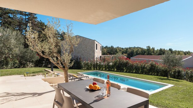 A poolside patio with a table, chairs, and a bottle of water. - Villa Casa Venus with pool in Istria, for 6 guests, quiet location, near Porec (Višnjan)
