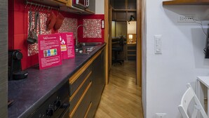 Eine moderne Küche mit roter und weißer Spritzschutzwand, Holzschränken und einer schwarzen Arbeitsplatte.