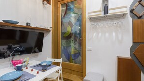 Eine Küche mit Esstisch, Stühlen und einem Fernseher.