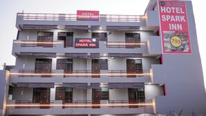 A multi-story hotel with balconies and a prominent sign advertising the Hotel Spark Inn. - Hotel Spark Inn || Near Motherhood Hospital (Noida)