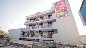 A multi-story hotel with balconies and a prominent sign advertising the Hotel Spark Inn. - Hotel Spark Inn || Near Motherhood Hospital (Noida)