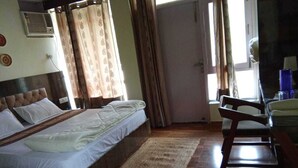 Un dormitorio con cama, una silla, un tapete y una puerta.
