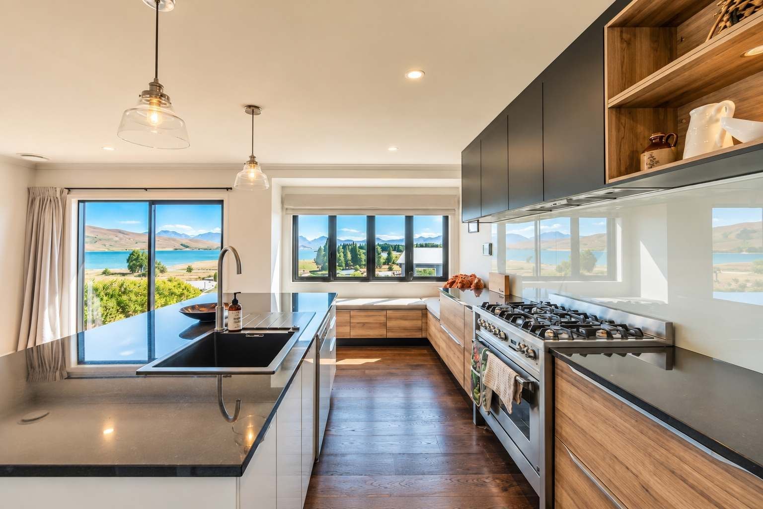 A modern kitchen with a large island, stainless steel appliances, and a view of a lake.