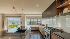 Una cocina moderna con una isla grande, horno integrado y vistas al exterior.