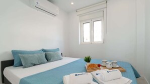 A hotel room with a bed, pillows, a tray with waffles and cups, and towels with the hotel logo.