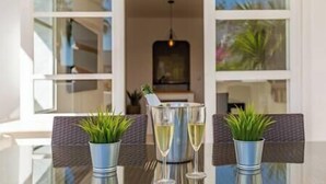 A table with two glasses of champagne, a bottle, and two potted plants. - Ground Floor Apartment at Matchroom Country Club (Mijas)
