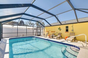 Ein überdachter Pool mit Glasdach, Liegestühlen und einem kleinen Fenster.